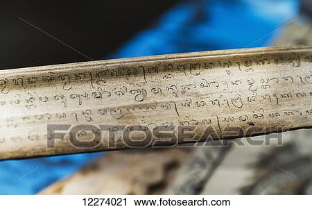 Stock Image - Carving in Sanskrit on lontar leaves, Tenganan Pegringsingan, Bali, Indonesia. Fotosearch