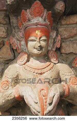 Stock Photograph - Carving of Narayan (Vishnu) holds a conch on the wall of a small temple; Bhaktapur, Nepal. Fotosearch