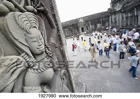 Stock Image - Carving On Temples, People In Background, Siem Reap, Cambodia. Fotosearch