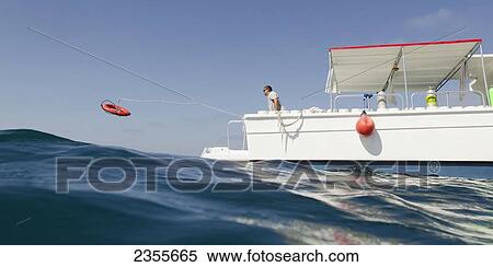 Stock Photography - Casting A Life Preserver Off The End Of A Boat Into The Water; Utila, Bay Islands, Honduras. Fotosearch