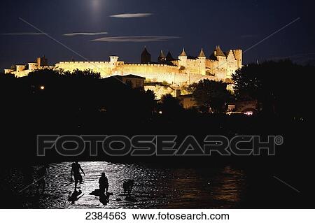 Stock Image - Castle and ramparts illuminated at night; Carcassonne, Languedoc-Rousillion, France. Fotosearch
