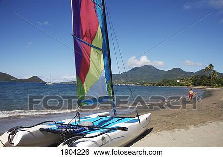 Catamaran On Sea Shore With Man Walking In Background View Large Photo Image Stock Photograph - Catamaran On Sea Shore With Man Walking In Background. Fotosearch