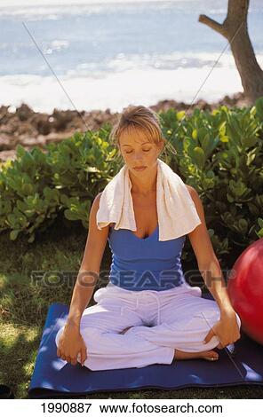 Caucasian Woman Sitting On Yoga Mat Near Ocean Meditating In Sunlight View Large Photo Image Stock Photo - Caucasian Woman Sitting On Yoga Mat Near Ocean Meditating In Sunlight. Fotosearch