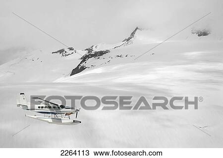 Cessna Caravan Amphibian Seaplane Flying Through The Coast Mountains; British Columbia Canada View Large Photo Image Stock Image - Cessna Caravan Amphibian Seaplane Flying Through The Coast Mountains; British Columbia Canada. Fotosearch