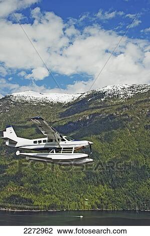 Stock Image - Cessna caravan amphibian seaplane flying along jervis inlet on the sunshine coast; british columbia canada. Fotosearch