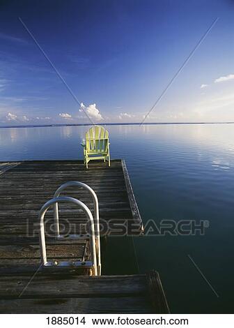 Picture - Chair On End Of Pier Beside Steps At Dawn. Fotosearch