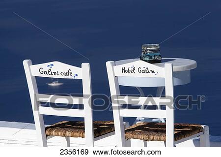 Chairs and a table on a patio overlooking the water from Hotel Galini and Galini Cafe; Firostefani, Santorini Island, Greece View Large Photo Image Stock Photo - Chairs and a table on a patio overlooking the water from Hotel Galini and Galini Cafe; Firostefani, Santorini Island, Greece. Fotosearch