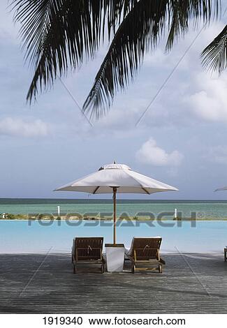 Chairs And Umbrella Beside The Pool View Large Photo Image Stock Image - Chairs And Umbrella Beside The Pool. Fotosearch