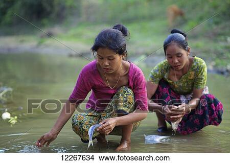 Picture - Chakma women cleaning fish; Khagrachari, Chittagong Division, Bangladesh. Fotosearch