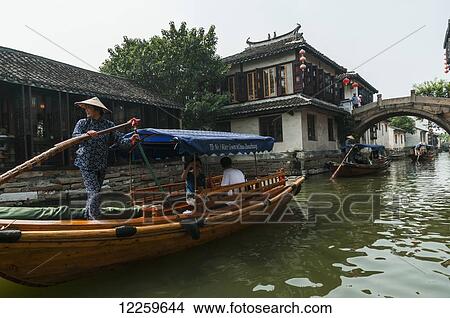 Picture - Channels the boatmen drive their boats as Venetia, beautiful traditional Chinese architecure as background; ZhouZhuang, Shanghai, China. Fotosearch