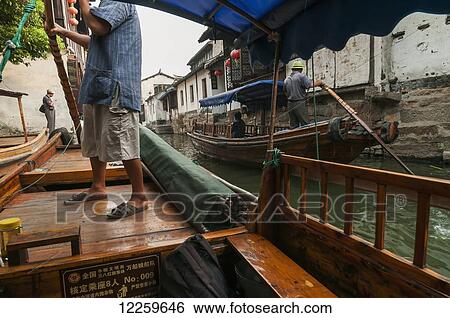 Stock Photograph - Channels the boatmen drive their boats as Venetia; ZhouZhuang, Shanghai, China. Fotosearch