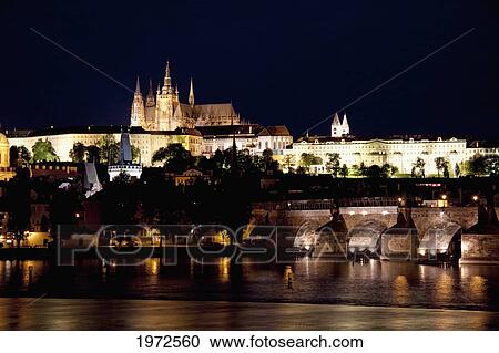 Stock Image - Charles Bridge And Prague Castle Reflected In The Vltava River At Night, Prague, Czech Republic. Fotosearch