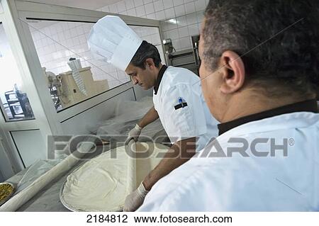 Stock Image - Chef Preparing Traditional Arabic Sweets, Mediterranean Sweets Or Middle Eastern Sweets Made At The Zalatimo Sweetshop, Amman, Jordan, Middle East. Fotosearch