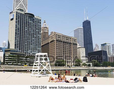 Picture - Chicago's sandy beach and W Hotel, with buildings of Chicago's Magnificent Mile on the left, including the spikes of the Hancock Tower; Chicago, Illinois, United States of America. Fotosearch