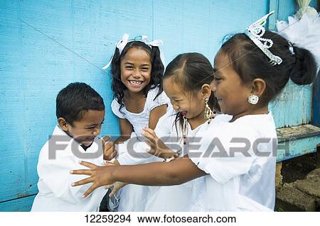 Children dressed in white formal wear against a blue wall; Hapai Island, Tonga View Large Photo Image Picture - Children dressed in white formal wear against a blue wall; Hapai Island, Tonga. Fotosearch