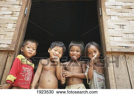 Stock Image - Children Laughing In Doorway, Bolaven Plateau, Champasak Province, Laos. Fotosearch