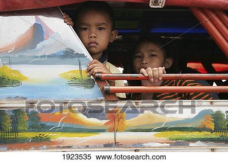 Stock Photography - Children Peeking From Ferry Window, Bolaven Plateau, Champasak Province, Laos. Fotosearch