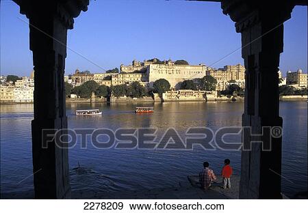 Children playing at the water's edge with a view of City Palace and lake; Udaipur, Rajasthan, India View Large Photo Image Stock Photo - Children playing at the water's edge with a view of City Palace and lake; Udaipur, Rajasthan, India. Fotosearch