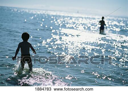 Stock Image - Children Playing In The Sea. Fotosearch