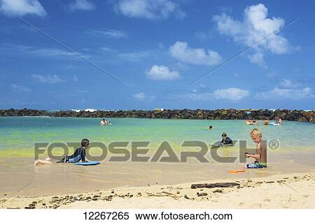 Stock Photography - Children playing in the water close to the shore, Lydgate Park; Kauai, Hawaii, United States of America. Fotosearch