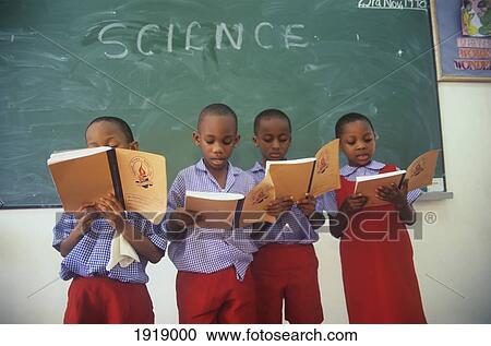 Stock Image - Children Reading From Exercise Books At School. Fotosearch