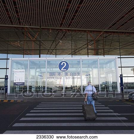 Stock Image - China, A Traveler With Luggage At Beijing Capital International Airport; Beijing. Fotosearch