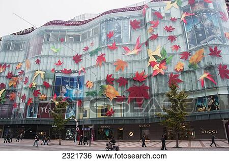 Stock Photograph - China, Beijing, Colorful leaves decoration on retail building facade. Fotosearch