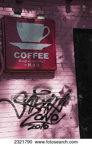 Stock Image - China, Beijing, Sign for coffee and painted graffiti in 798 Art Zone. Fotosearch