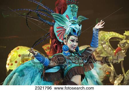 Stock Photograph - China, Beijing, Young woman in extravagant and colorful costume with large headpiece. Fotosearch
