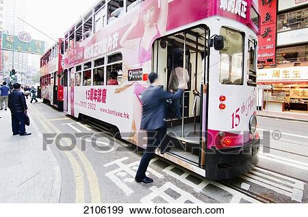 Stock Photo - China, Hong Kong, Man boarding on cable car; Wanchai. Fotosearch