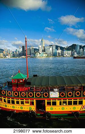 China, Kowloon; Hong Kong, Brightly painted tour boat with Victoria Harbor and Hong Kong Island skyline in backgroundv view form Tsim Sha Tsui View Large Photo Image Stock Photo - China, Kowloon; Hong Kong, Brightly painted tour boat with Victoria Harbor and Hong Kong Island skyline in backgroundv view form Tsim Sha Tsui. Fotosearch