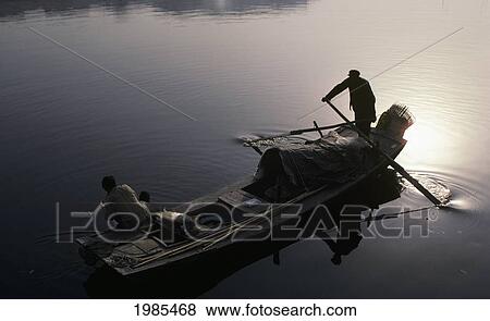 Stock Photo - China, Tianjin, Hai River, Silhouetted Fishermen In Boat, View From Above.. Fotosearch