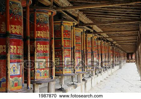Stock Image - China, Xiahe, Row Of Colorful Prayer Wheels; Labrange Monastery. Fotosearch