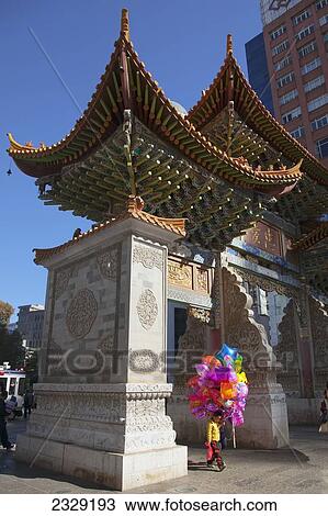 Stock Image - China, Yunnan, Boy carrying colorful balloons; Kunming. Fotosearch