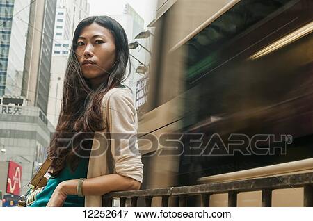 Chinese young woman in a busy, urban centre; Hong Kong, China View Large Photo Image Stock Photo - Chinese young woman in a busy, urban centre; Hong Kong, China. Fotosearch