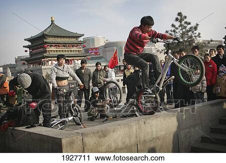 Chinese Youths Riding Mountain Bikes Near An Ancient Bell Tower, Xian, Xi'an, Capital Of Shaanxi Province, China View Large Photo Image Stock Image - Chinese Youths Riding Mountain Bikes Near An Ancient Bell Tower, Xian, Xi'an, Capital Of Shaanxi Province, China. Fotosearch