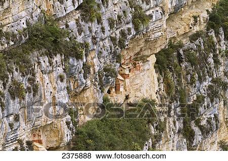 Stock Photo - Chullpas (stone tomb chambers) of the Chachapoya culture nestled in the limestone cliffs of Cerro Carb. Fotosearch