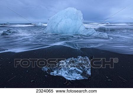 Stock Photography - Chunks of ice get pounded by the ocean surf near the glacial lagoon Jokulsarlon; Iceland. Fotosearch