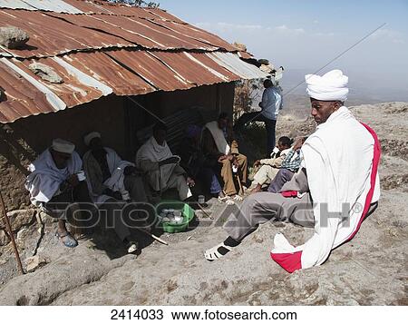 Stock Image - Church men drinking local tella beer at Easter, Asheten Maryam church; Lalibela, Asmara region, Ethiopia. Fotosearch