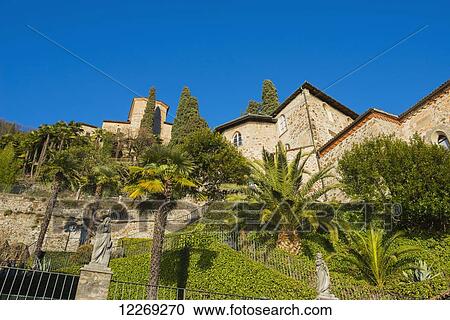 Church surrounded by lush foliage and palm trees; Lugano, Ticino, Switzerland View Large Photo Image Stock Image - Church surrounded by lush foliage and palm trees; Lugano, Ticino, Switzerland. Fotosearch