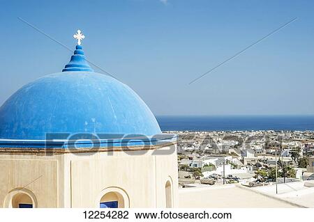 Stock Image - Church with a blue dome roof and view of the Aegean sea; Megalochori, Santorini, Greece. Fotosearch