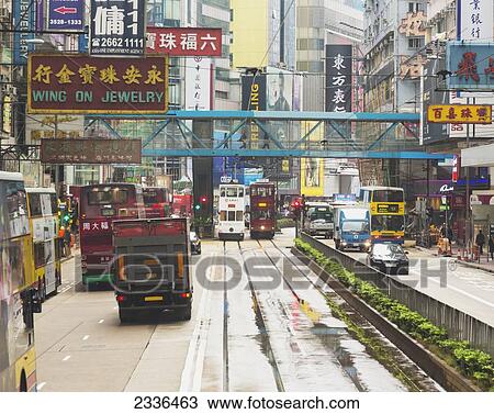 Stock Image - City Street With Signs And Buses And Trams; Hong Kong, China. Fotosearch