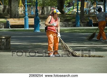 Picture - City Worker Sweeping A Public Square With A Palm Tree Branch; Mendoza Argentina. Fotosearch