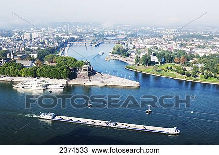 Stock Image - Cityscape of Koblenz with a barge in the River Rhine and a gondola; Koblenz, Germany. Fotosearch
