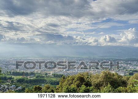 Cityscape With Clouds Overhead; Mangshi Yunnan China View Large Photo Image Stock Photo - Cityscape With Clouds Overhead; Mangshi Yunnan China. Fotosearch