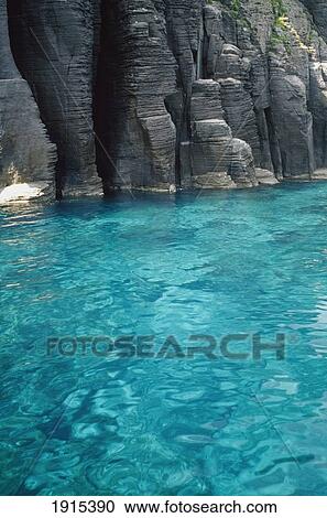 Stock Image - Clear Blue Water And Rocks. Fotosearch
