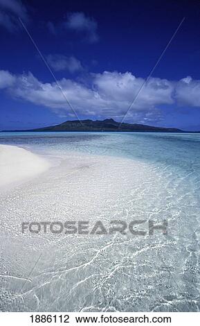 Stock Image - Clear Water On Tropical Beach With Island In Background. Fotosearch
