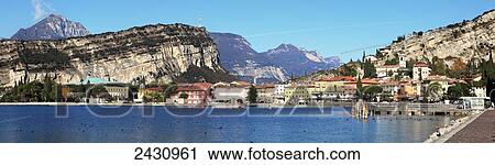 Cliffs and buildings along the shoreline of Lake Garda; Torbole, Trentino, Italy View Large Photo Image Stock Image - Cliffs and buildings along the shoreline of Lake Garda; Torbole, Trentino, Italy. Fotosearch