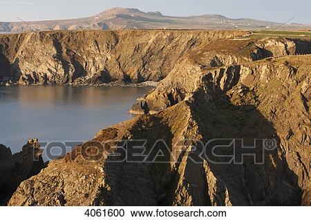 Stock Image - Cliffs at sundown near Trefin village on the Pembrokeshire Coast Path, South West Wales; Pembrokeshire, Wales. Fotosearch