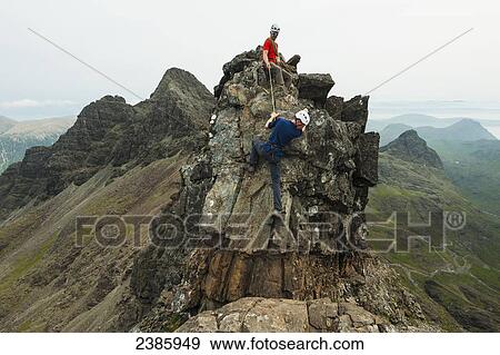 Stock Photo - Climber with rope on descending part of the ridge below Bruach na Frithe in the Black Cuillin; Isle of Skye, Scotland. Fotosearch